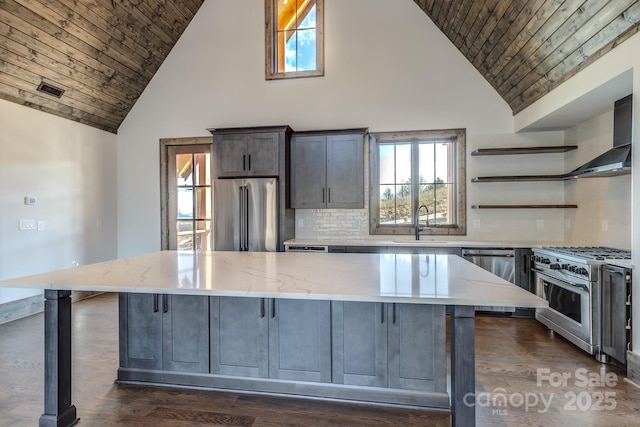 kitchen featuring a breakfast bar, a large island, open shelves, light stone countertops, and high quality appliances