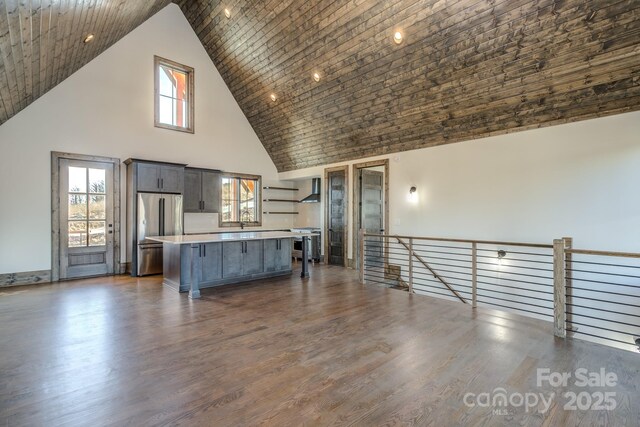 kitchen featuring dark wood-style floors, a breakfast bar, stainless steel appliances, light countertops, and a kitchen island