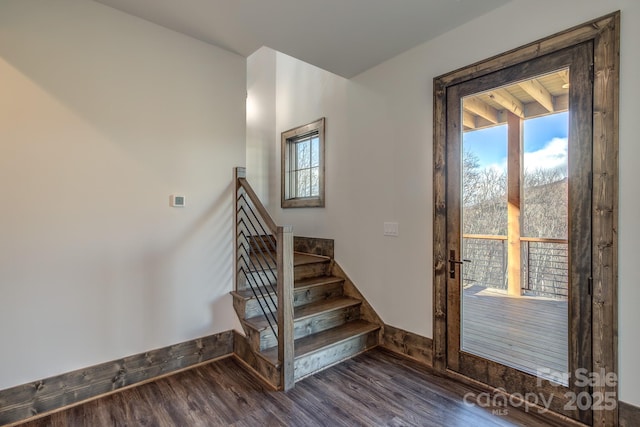 stairs with baseboards, wood finished floors, and a healthy amount of sunlight