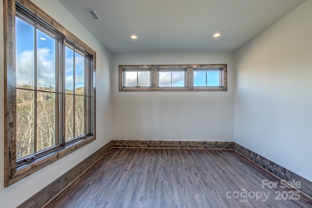 empty room featuring recessed lighting, visible vents, baseboards, and wood finished floors