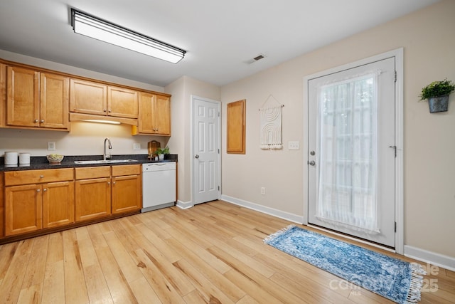 kitchen featuring brown cabinetry, visible vents, a sink, dishwasher, and light wood-type flooring