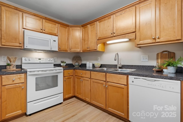 kitchen featuring white appliances, sink, and light hardwood / wood-style flooring