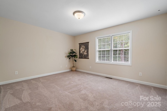 empty room featuring baseboards, visible vents, and carpet floors