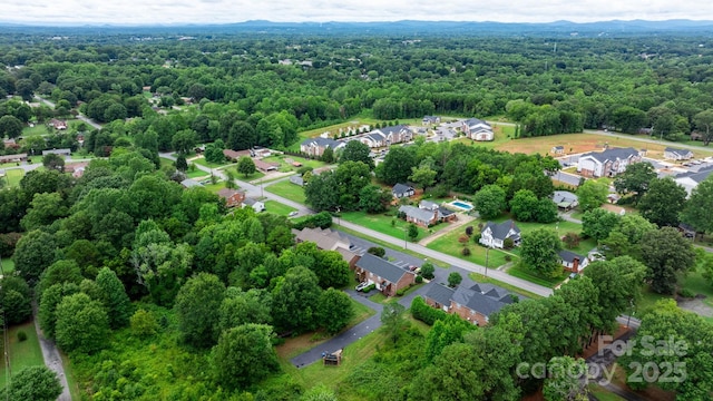 bird's eye view featuring a wooded view and a residential view