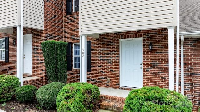 view of exterior entry featuring brick siding