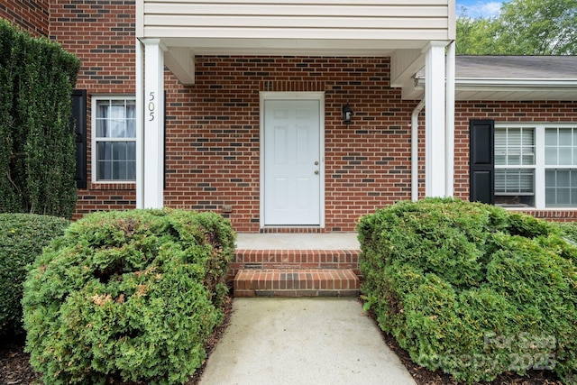 doorway to property featuring brick siding