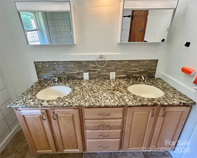 bathroom with tile patterned flooring, double sink vanity, and backsplash