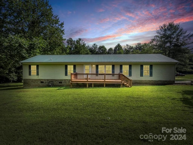 ranch-style house featuring a deck and a yard