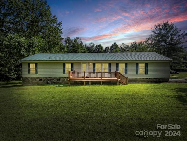 view of front of home featuring metal roof, crawl space, a deck, and a lawn