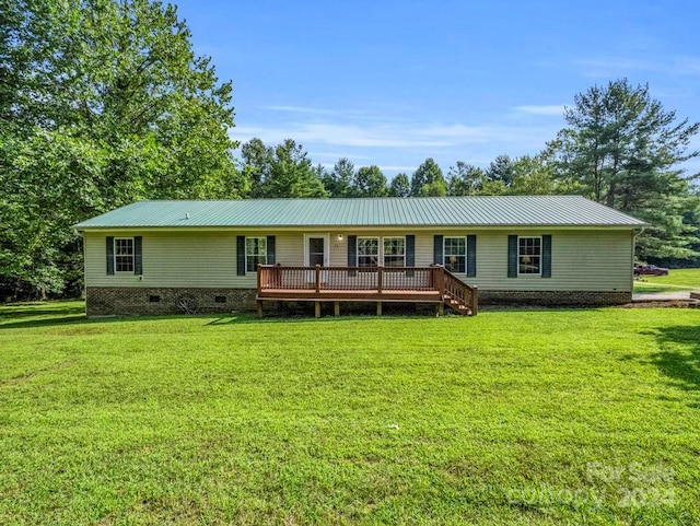 single story home featuring a wooden deck and a front yard