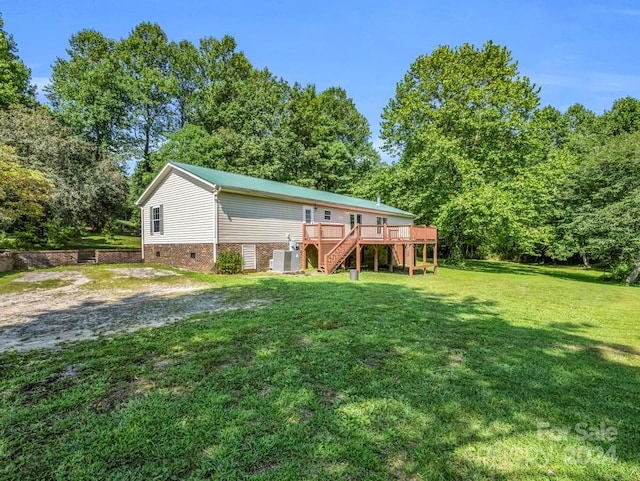 rear view of house with a wooden deck and a yard