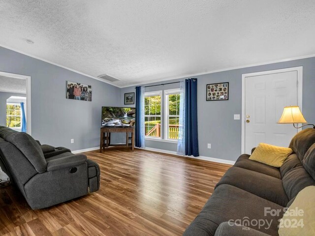 living room featuring plenty of natural light, hardwood / wood-style floors, and ornamental molding