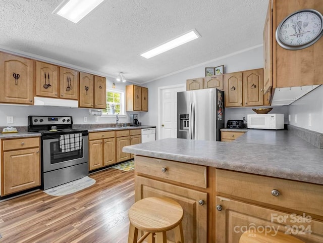 kitchen featuring appliances with stainless steel finishes, lofted ceiling, a textured ceiling, and light wood-type flooring