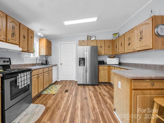 kitchen featuring sink, light hardwood / wood-style flooring, white appliances, vaulted ceiling, and a textured ceiling