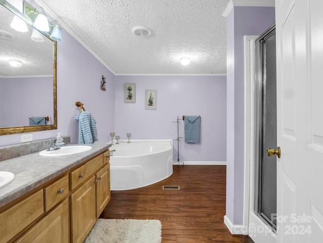 bathroom with hardwood / wood-style floors, a textured ceiling, and dual vanity