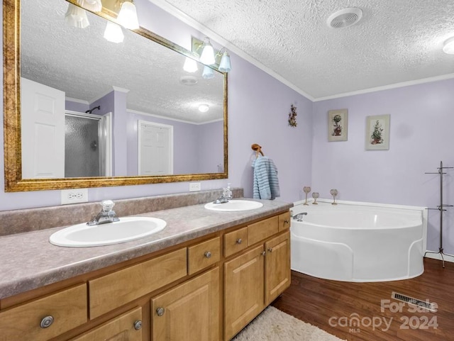 bathroom featuring a textured ceiling, crown molding, dual vanity, and hardwood / wood-style flooring