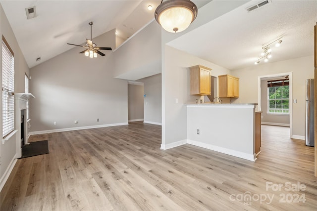 unfurnished living room featuring a fireplace with flush hearth, visible vents, and light wood finished floors