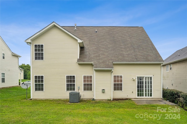 rear view of house featuring a yard, central AC, a patio area, and roof with shingles