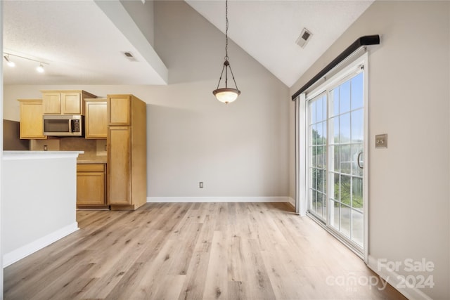 unfurnished living room with lofted ceiling, baseboards, visible vents, and light wood-style floors