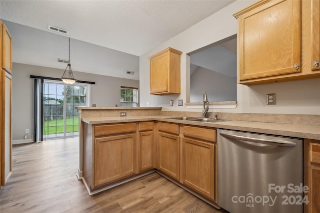 kitchen with a sink, visible vents, light countertops, stainless steel dishwasher, and light wood finished floors