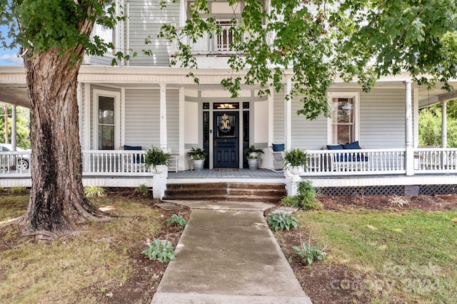 entrance to property with a balcony and covered porch