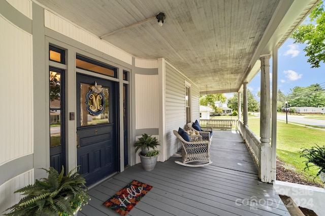 wooden deck featuring a yard and covered porch