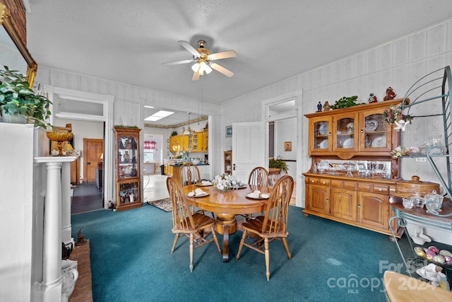 dining room with ceiling fan, a textured ceiling, and dark carpet