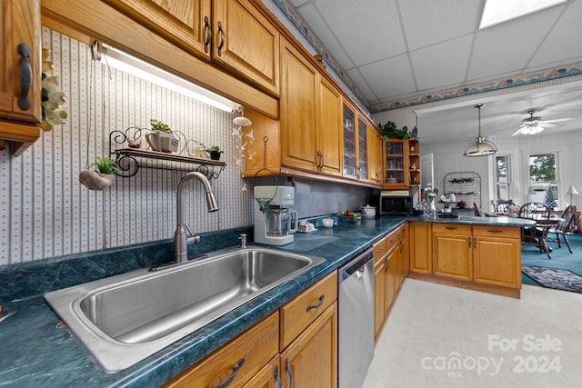 kitchen with pendant lighting, sink, appliances with stainless steel finishes, a drop ceiling, and kitchen peninsula