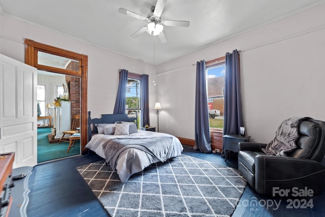 bedroom with ceiling fan, dark hardwood / wood-style flooring, and multiple windows