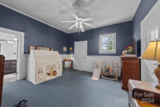 carpeted bedroom with ornamental molding, ceiling fan, and ensuite bathroom