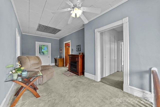 carpeted living room featuring ceiling fan and ornamental molding