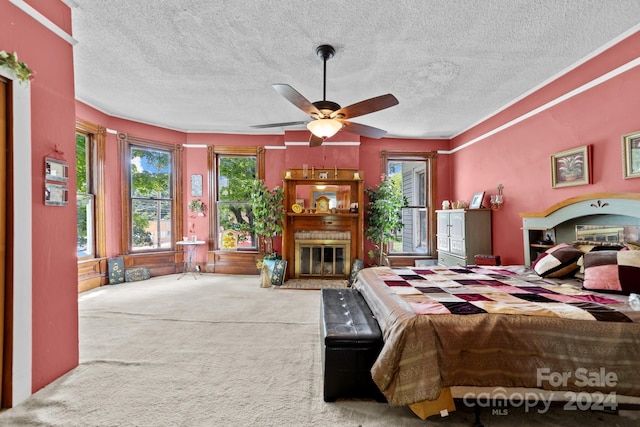 bedroom with ceiling fan, carpet flooring, a textured ceiling, and a fireplace