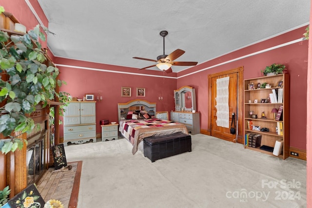 carpeted bedroom featuring a brick fireplace, a textured ceiling, and ceiling fan