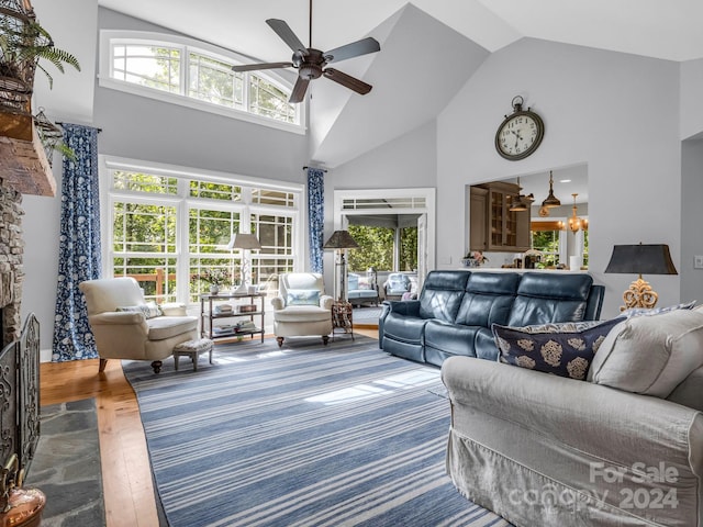 living room featuring ceiling fan with notable chandelier, high vaulted ceiling, and wood-type flooring