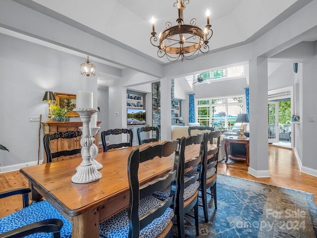 dining area with lofted ceiling, a chandelier, and hardwood / wood-style floors