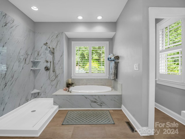 bathroom featuring plenty of natural light and plus walk in shower