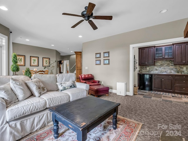 carpeted living room featuring ceiling fan and sink