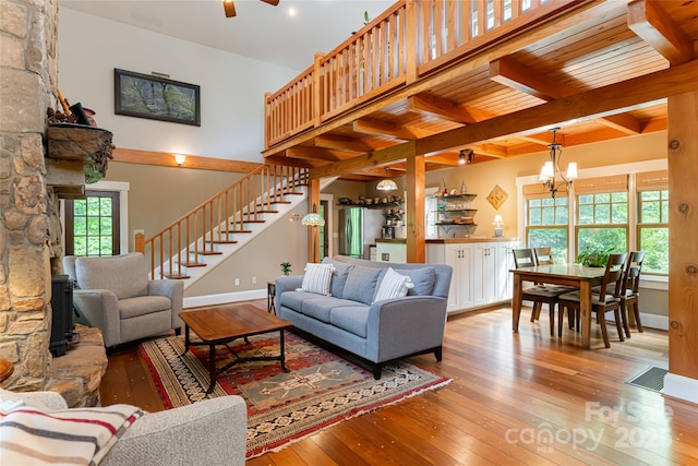 living area with stairway, baseboards, visible vents, beam ceiling, and wood-type flooring