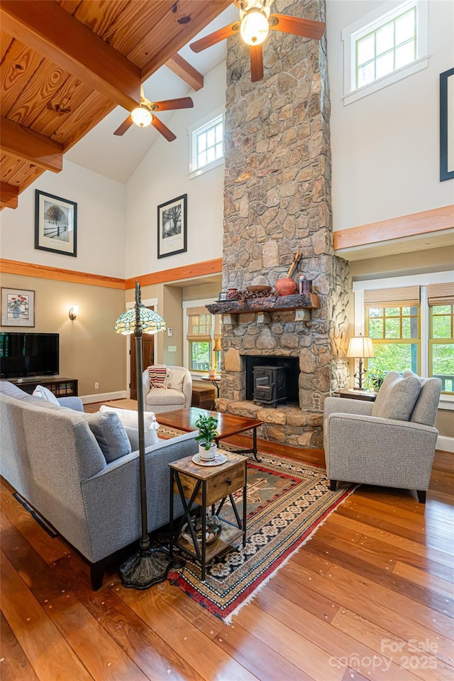 living area with beam ceiling, high vaulted ceiling, a ceiling fan, and wood-type flooring