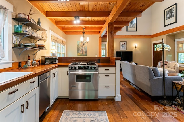 kitchen featuring a notable chandelier, butcher block countertops, open floor plan, appliances with stainless steel finishes, and a peninsula