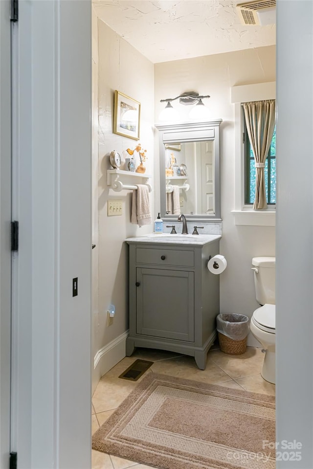 bathroom with tile patterned flooring, visible vents, toilet, and vanity