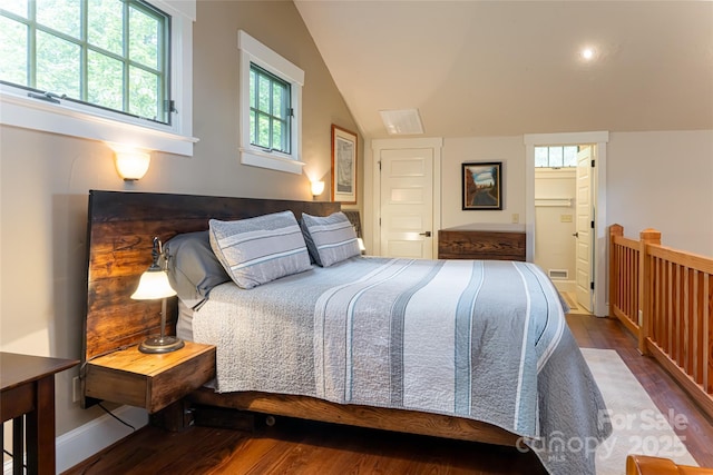 bedroom featuring baseboards, lofted ceiling, and wood finished floors