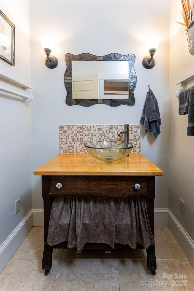 bathroom with baseboards, backsplash, and vanity