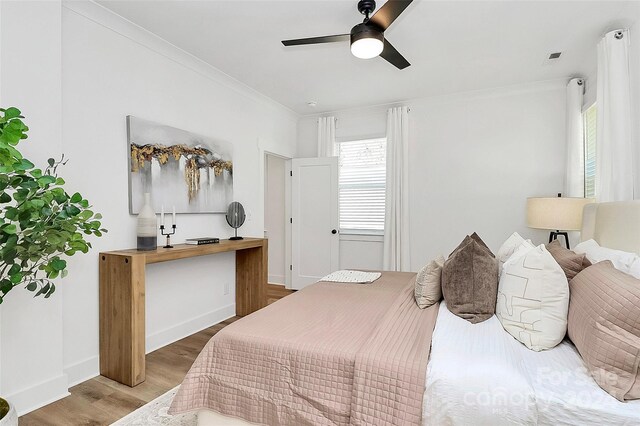 bedroom featuring crown molding, hardwood / wood-style flooring, and ceiling fan