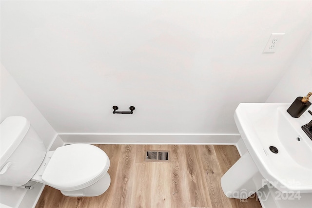 bathroom with hardwood / wood-style floors, toilet, and sink