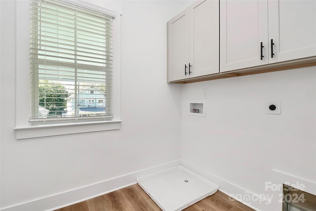 washroom featuring hookup for a washing machine, cabinets, hardwood / wood-style floors, and hookup for an electric dryer