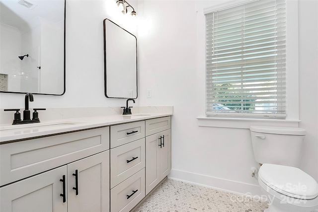 bathroom with walk in shower, vanity, and toilet