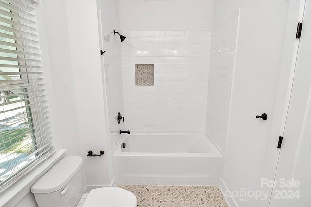 bathroom with tiled shower / bath and toilet