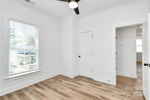 unfurnished bedroom featuring ceiling fan, multiple windows, a closet, and light wood-type flooring