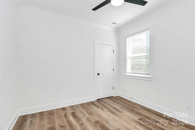 empty room featuring ornamental molding, light hardwood / wood-style floors, and ceiling fan